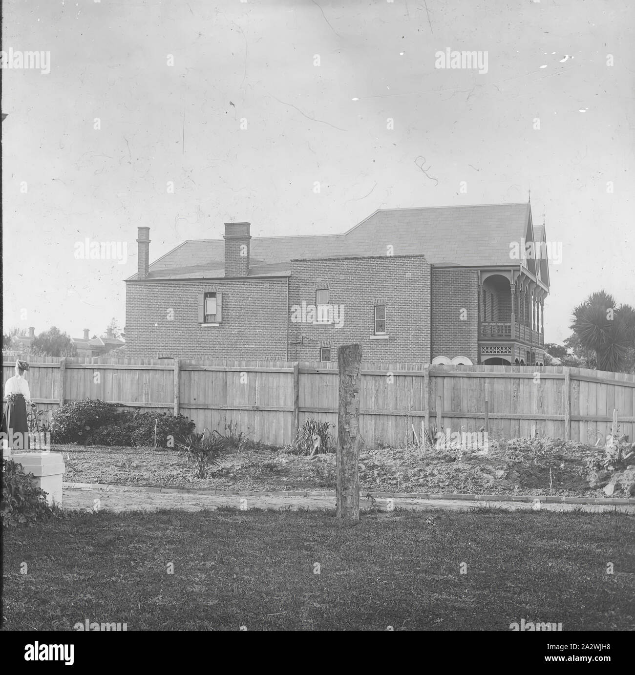 Lantern Slide - Suburban Home, Australia, Date Unknown, Black and white image looking across a newly established suburban garden to the neighbour's two storey home over the fence, photographed by A.J. Campbell Stock Photo