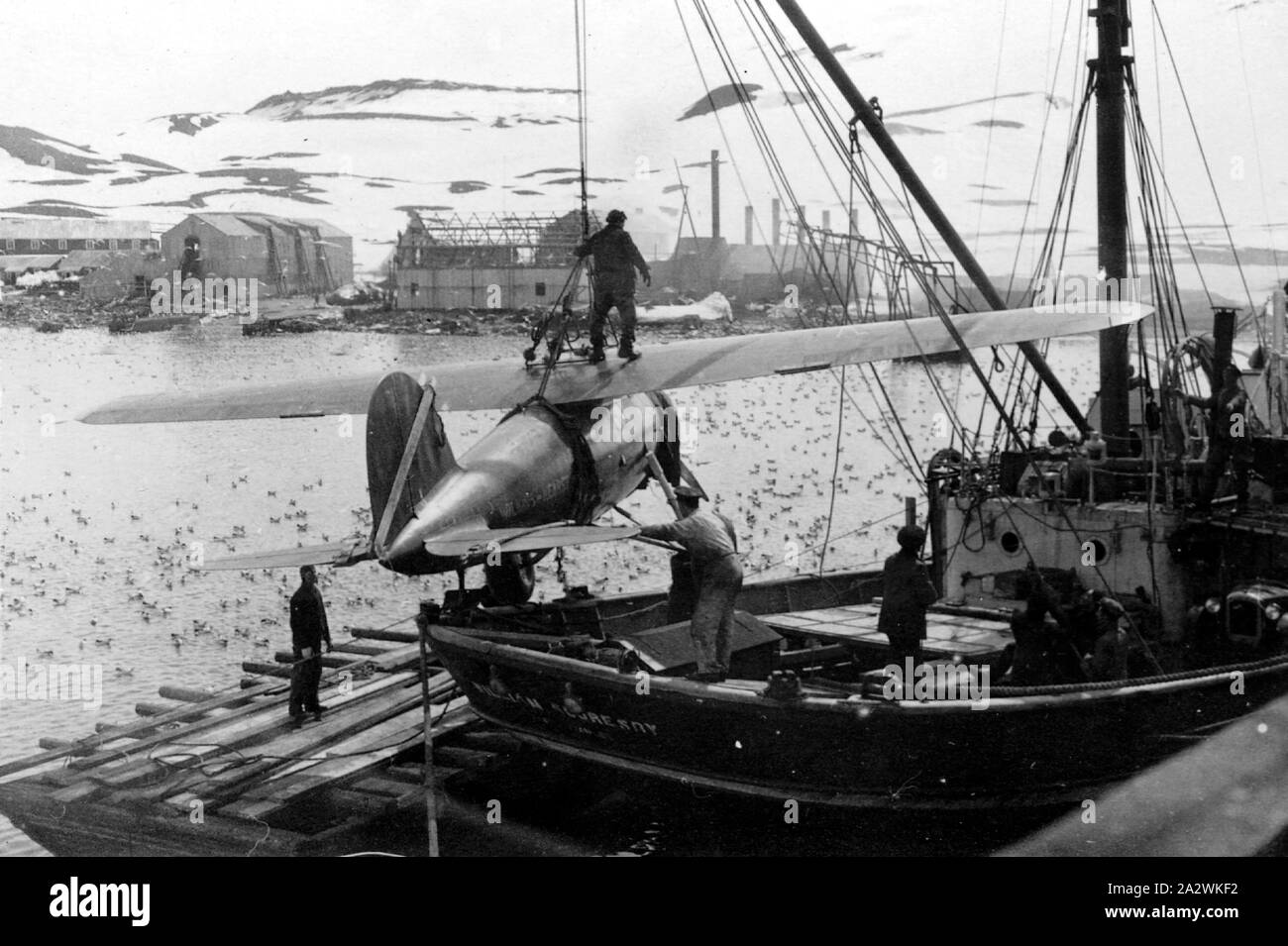 Photograph - George Rayner, Lockheed Vega, Antarctica, 1928, UNLOADING A LOCKHEED VEGA AEROPLANE FROM SHIP. AEROPLANE IS MARKED WILKINS HEARST. THE SHIP IS THE WILLIAM SCORESBY. PROBABLY TAKEN BY GEORGE RAYNER Stock Photo