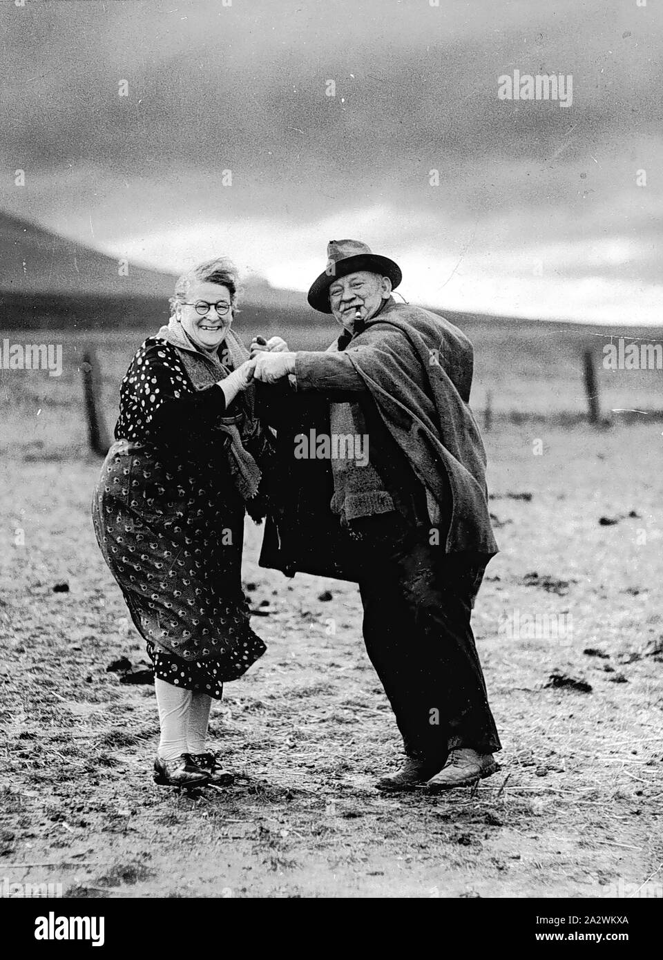 Negative - Beveridge District, Victoria, circa 1931, Copy negative of a couple dancing after three days of heavy rain broke an extended drought in the early 1930s. Francis (Frank) James Smith and Bridget Smith owned a mixed farm called Mt Fraser, near Beveridge, Victoria. The photograph was taken by a photographer from The Sun newspaper, Melbourne. The couple had previously farmed in Tower Hill, Victoria and moved to Beveridge in 1913. They had Stock Photo