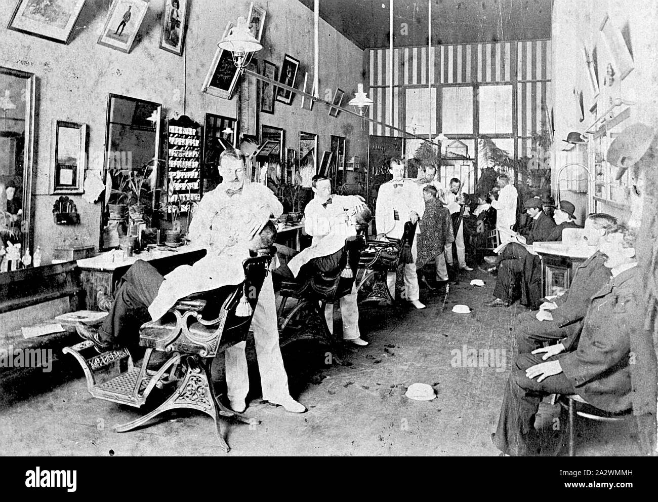 Negative - Barbers & Customers in the Scott Family's Barber Shop, Ballarat, Victoria, circa 1905, Barbers and customers in the barber's shop owned by the Scott family Stock Photo