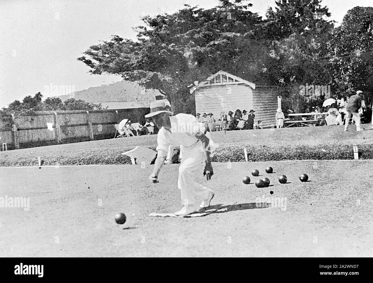 Negative - Man Playing Bowls at 'Erskine House', Lorne, Victoria, 1920, A man playing bowls at 'Erskine House'. A small group of people watch in the background Stock Photo