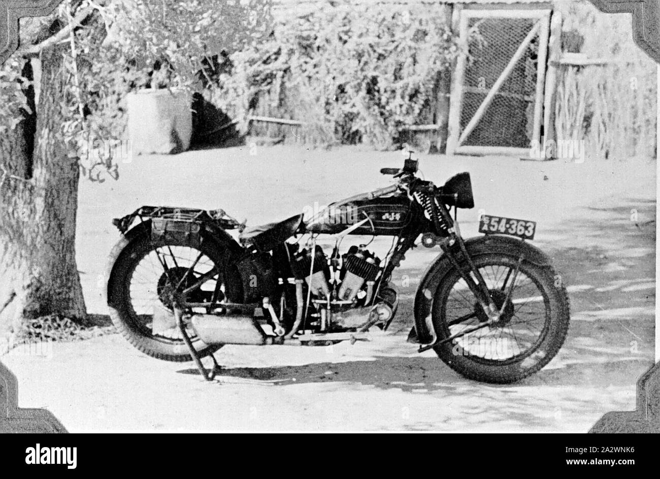 Negative - Henbury, Northern Territory, 1937, A AJS V-twin motorbike at 'Henbery' station. There is a brush covered building in the background Stock Photo