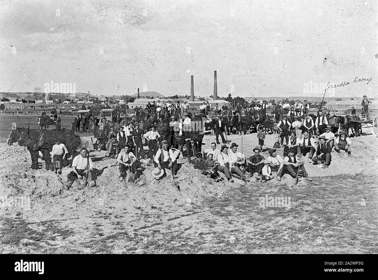 Negative - Ballarat Showgrounds, Victoria, circa 1930, Men and horses on a working bee at the Ballarat Showgrounds. An arrow points to a man identified as 'Grandpa Davey'. The chimneys of a mill can be seen in the background Stock Photo