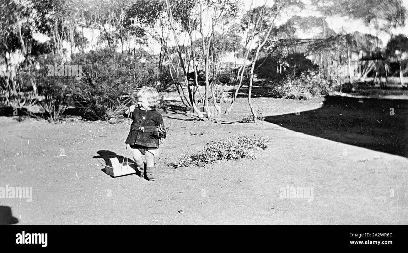 Negative - Prooinga, Victoria, 1933, A small girl playing with a toy. The toy may be a dolls crib Stock Photo