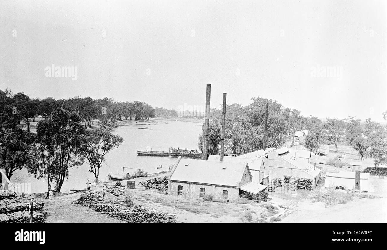 Negative - Mildura, Victoria, circa 1925, The Murray River at Mildura. The buildings in the foreground have very tall chimneys and there are large wood piles on the left Stock Photo
