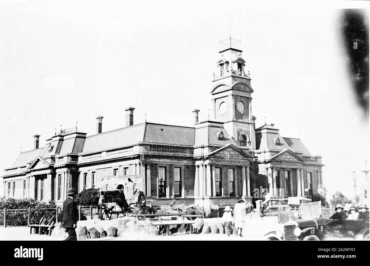 Negative - Ararat, Victoria, circa 1925, The Ararat Town Hall. There are three women in a motor car on the right and a field gun on display on the left Stock Photo
