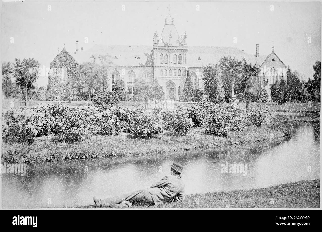 Negative - Melbourne, Victoria, circa 1885, The National Museum, established in the grounds of Melbourne University in 1862. In the foreground is a man reclining on the banks of a lake Stock Photo