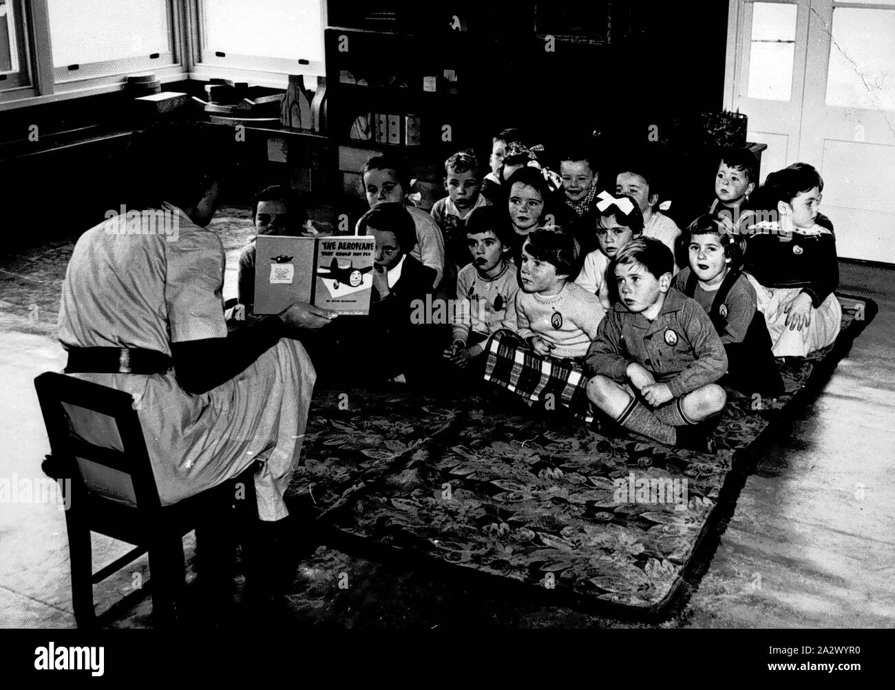 Negative - Flemington, Victoria, 1955, A student teacher reading a story book to a prep class at St Brendans Primary School Stock Photo