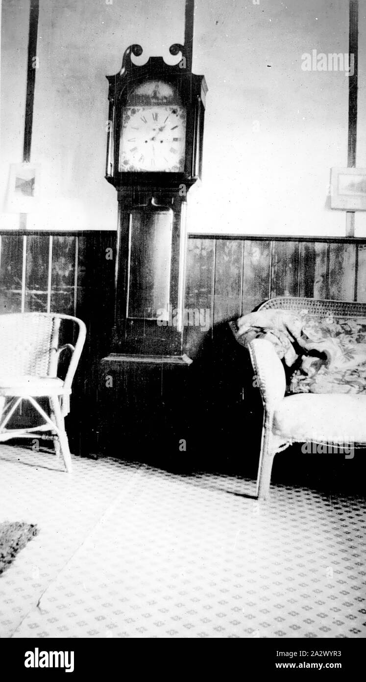 Negative - Rupanyup (?), Victoria, circa 1935, Inside a sitting room with a grandfather clock flanked by a cane chair and a sofa Stock Photo