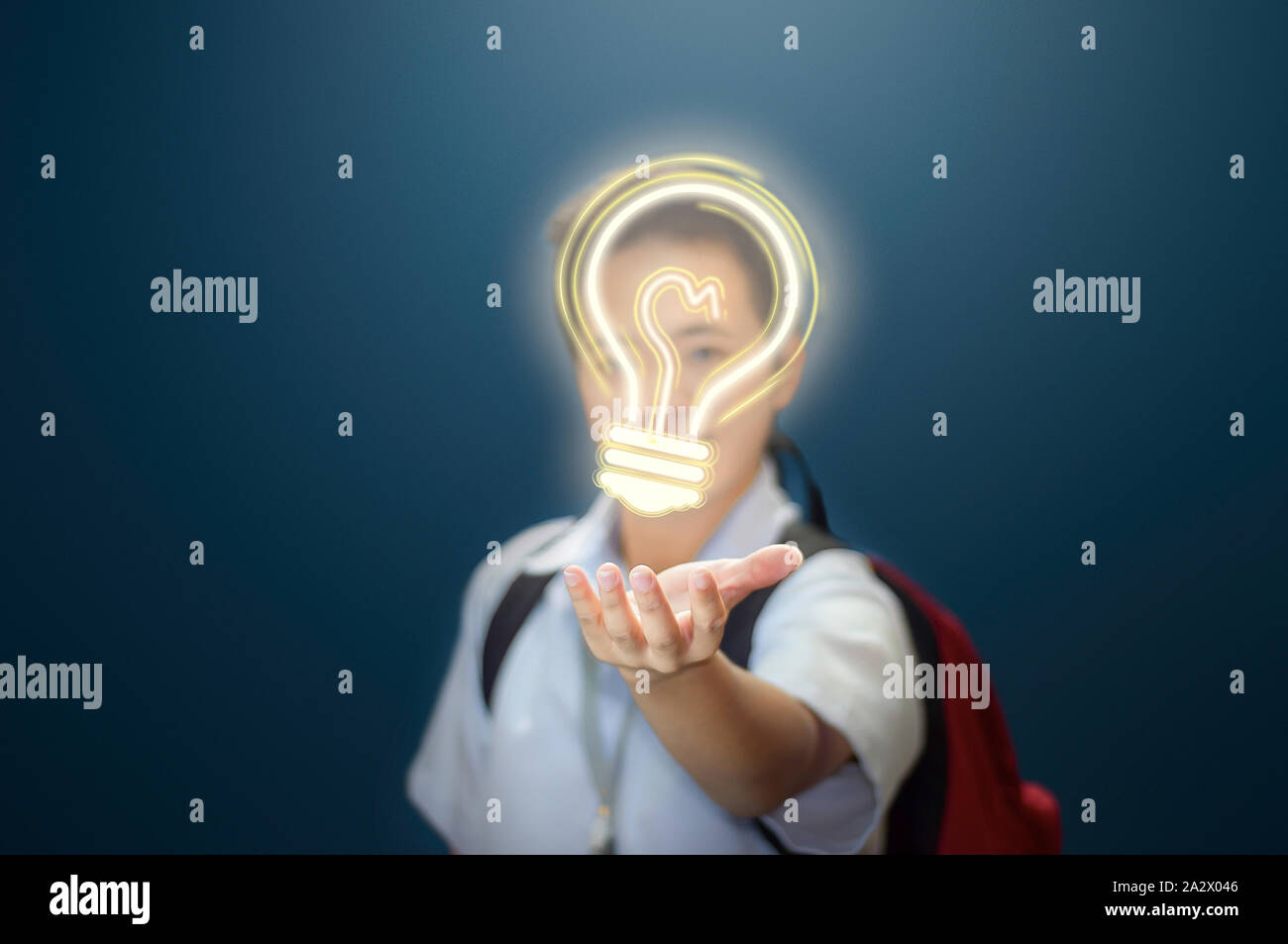 Young boy giving an idea. Student showing a light bulb to present an idea, Stock Photo