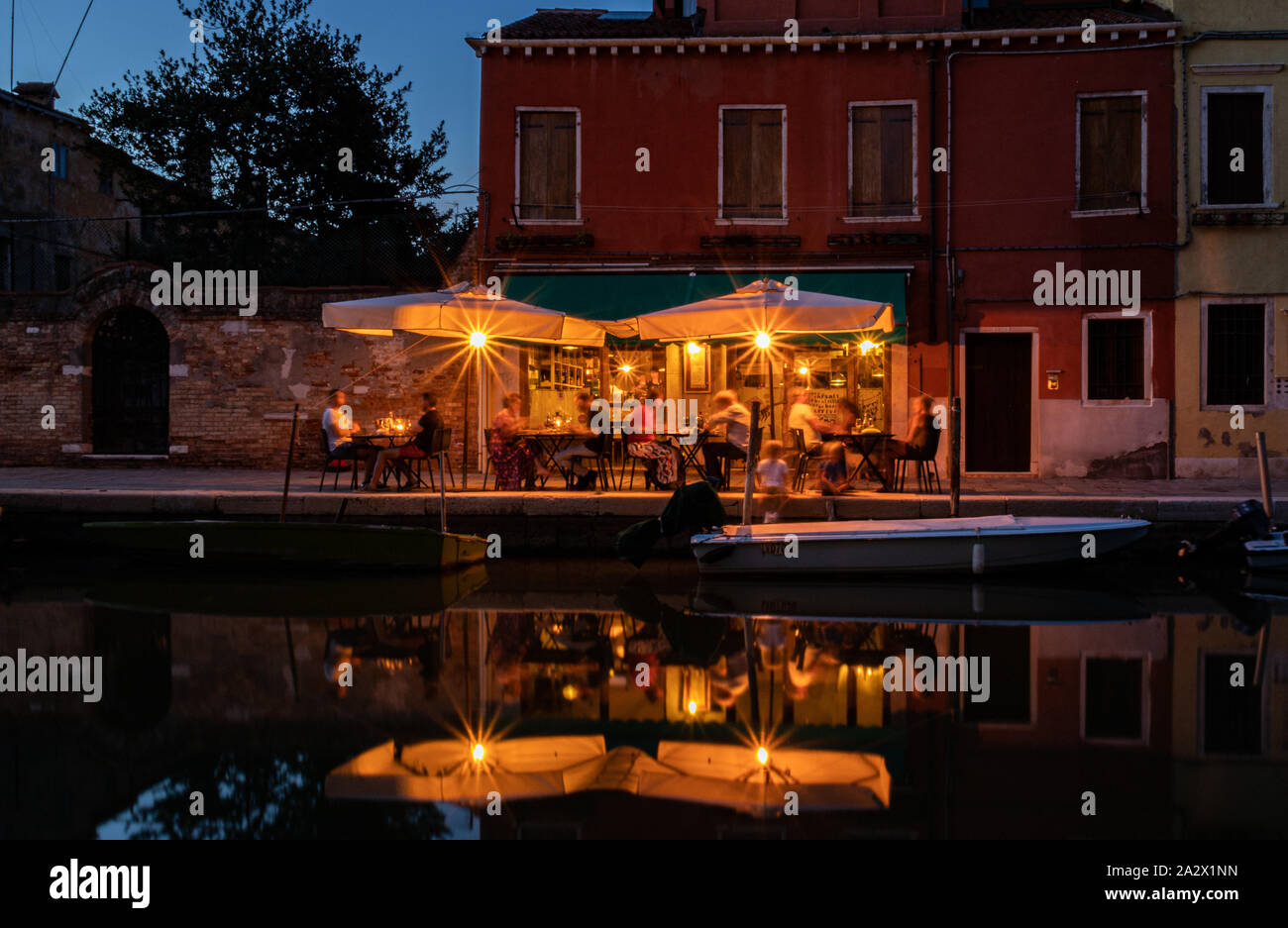 Al fresco dining in Venice with canal reflection Stock Photo