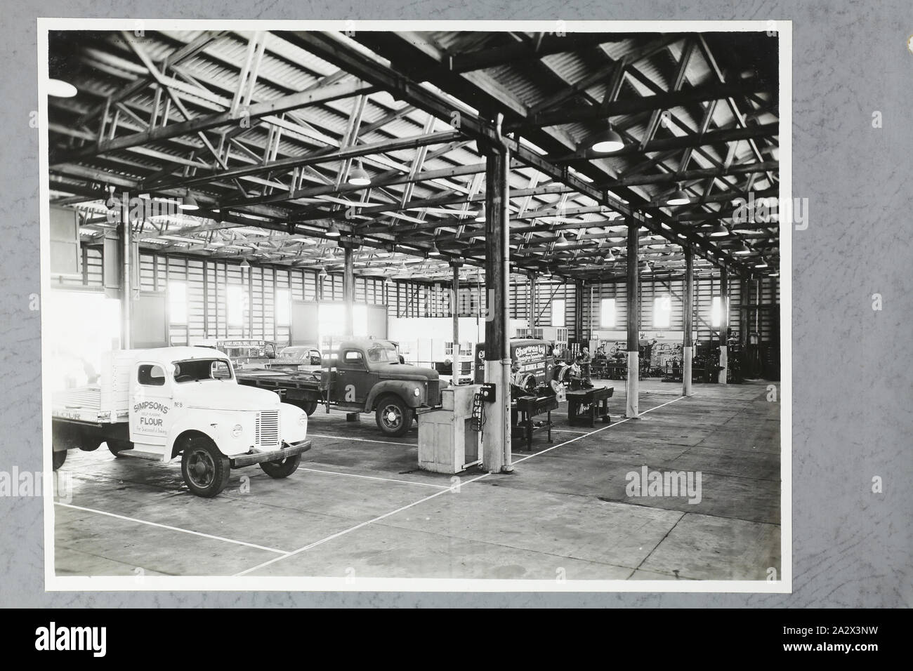 Photograph - International Harvester, Truck Service Workshop Interior, Brisbane, 09 Jan 1947, One of four black and white photographs attached to an album page. The page is one of 28 that previously made up a photograph album containing black & white photographs of the International Harvester Company's state branch offices and showrooms throughout Australia. Part of a large collection of glass plate and film negatives, transparencies, photo albums, product catalogues, videos Stock Photo