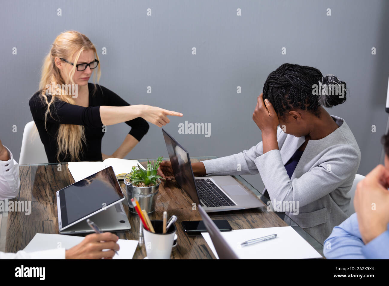 Angry Business Woman Blaming Female Colleague In Meeting For Business Mistake In Office Stock Photo