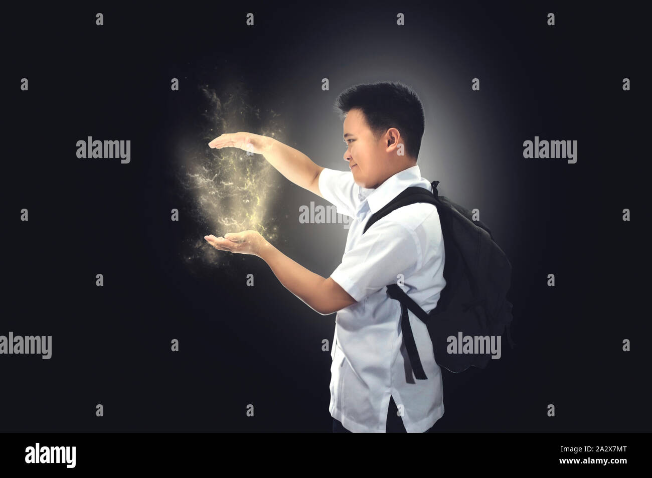 Happy young male student in school uniform with back pack showing something with hand gestures. Idea concept. Success, creative, and idea concept Stock Photo
