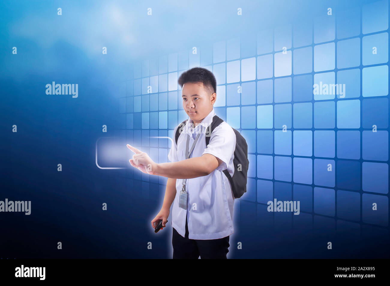 Teenage boy student in school uniform with backpack using holographic screen in advance technology concept Stock Photo