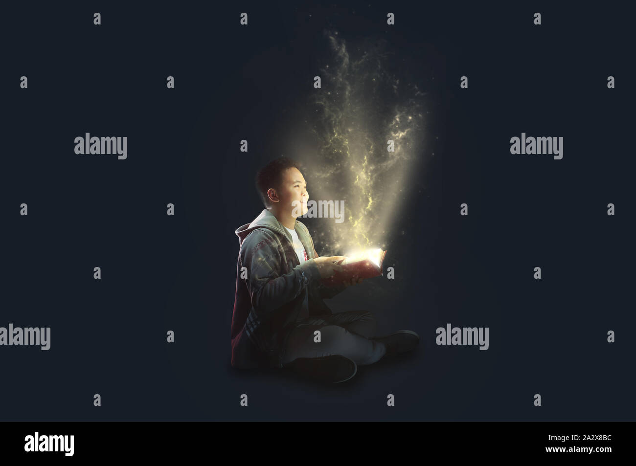 A Collage student open a book with beams of light coming out. Popping knowledge concept. Stock Photo