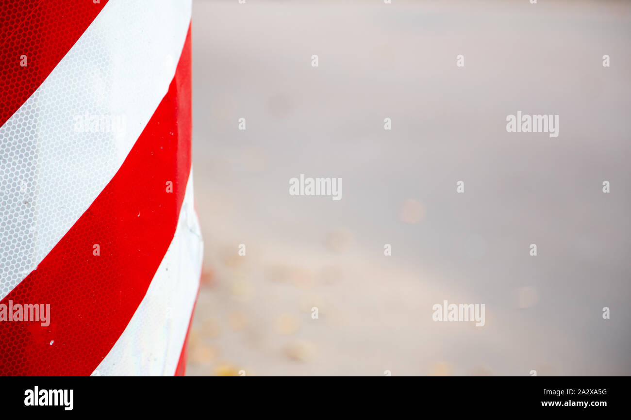Red and white striped concrete road barrier close up with copy space ...