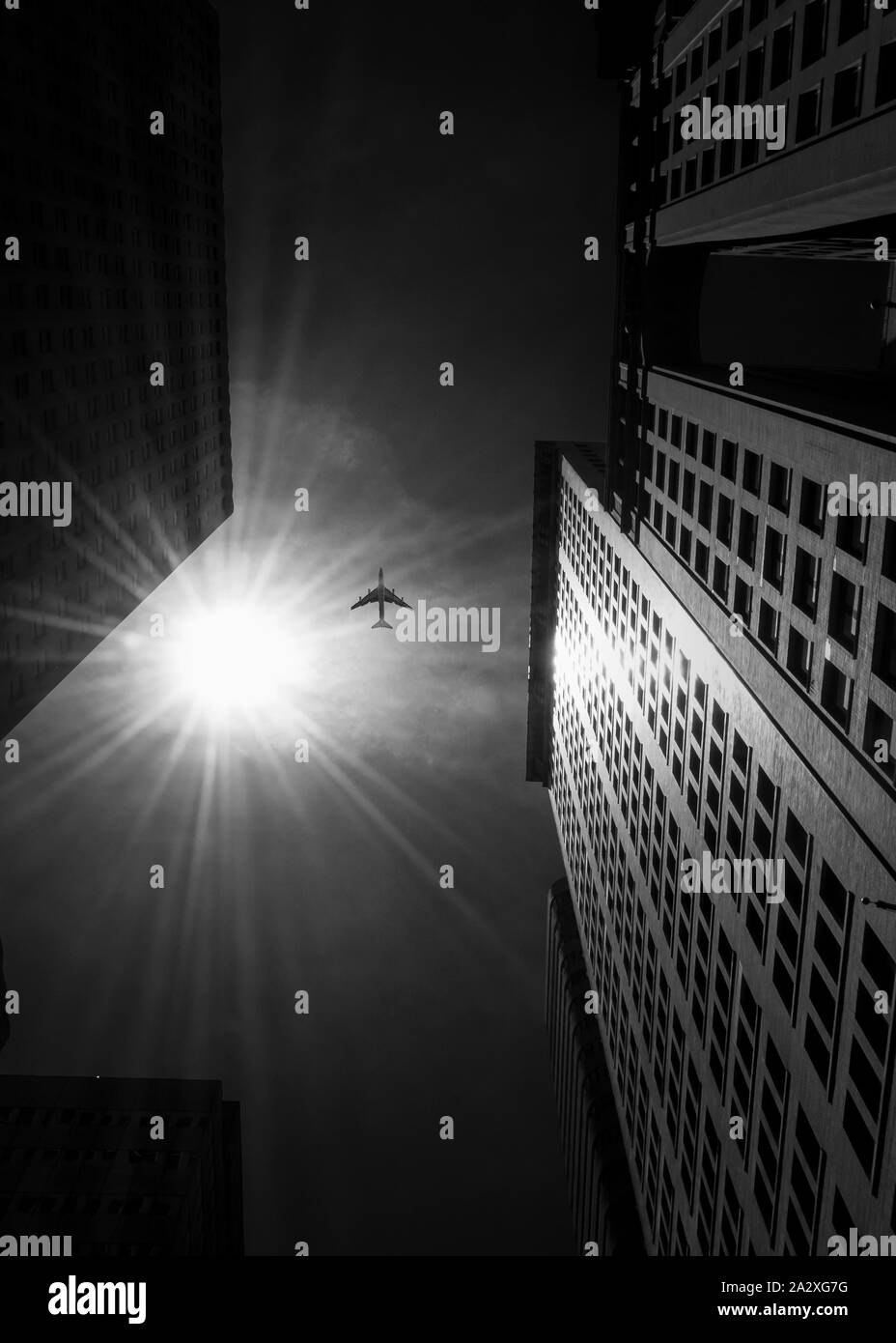 Low angle black and white photo of airplane flying in Manhattan Stock Photo