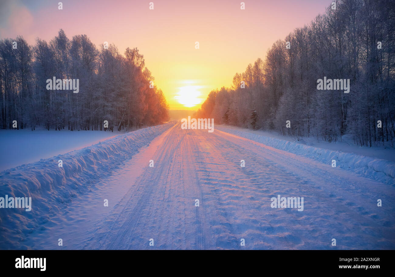 Sun over siberian rural empty road under the snow at morning time ...