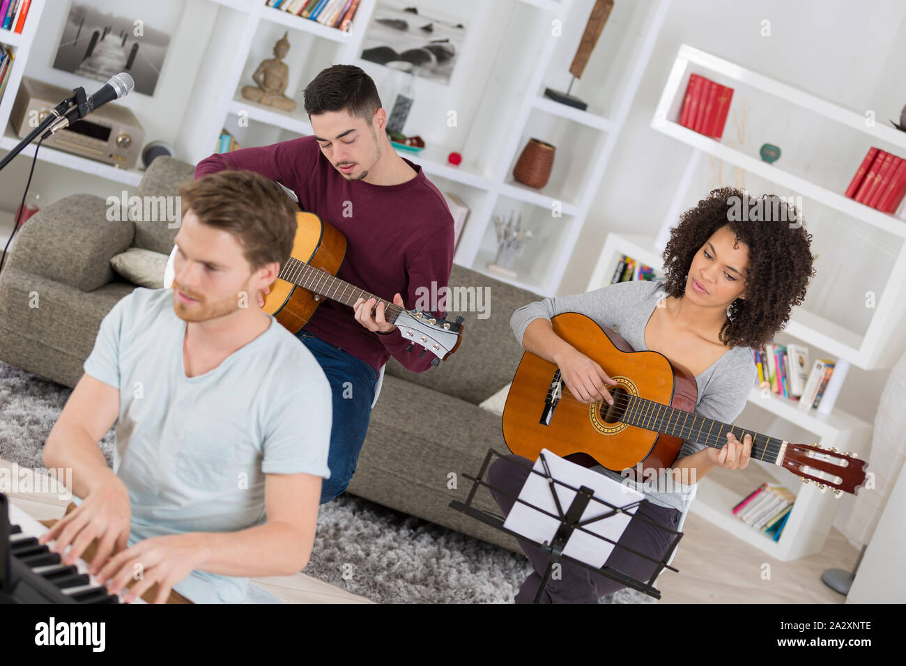 three musicians playing together two guitarists and one on keyboard