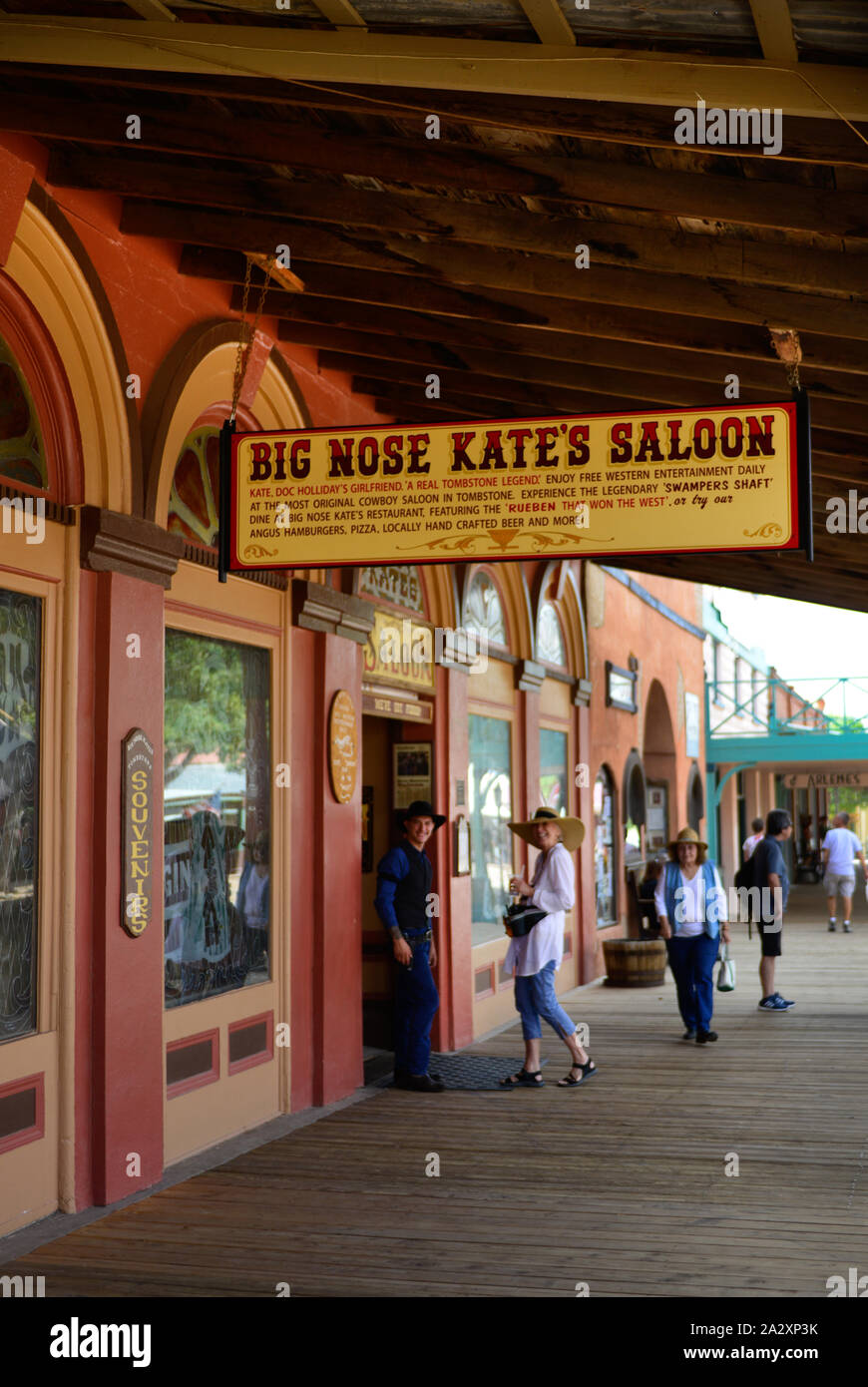 Tourists enjoy the culture of Tombstone, AZ, with Doc Holidays girlfriend, Big Nose Kates namesake Saloon with big sign along the portico Stock Photo