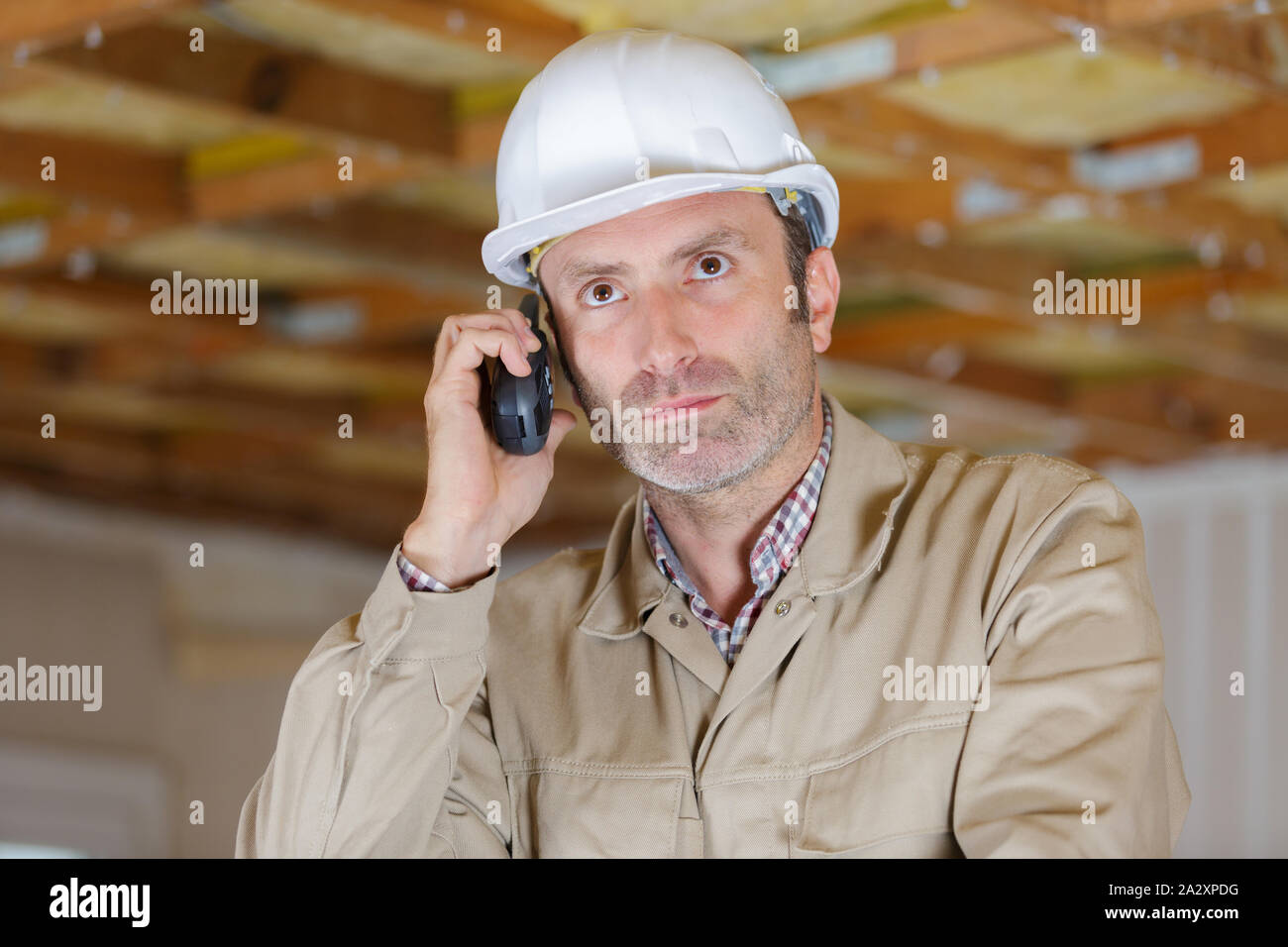 builder in helmet talking on walkie talkie Stock Photo