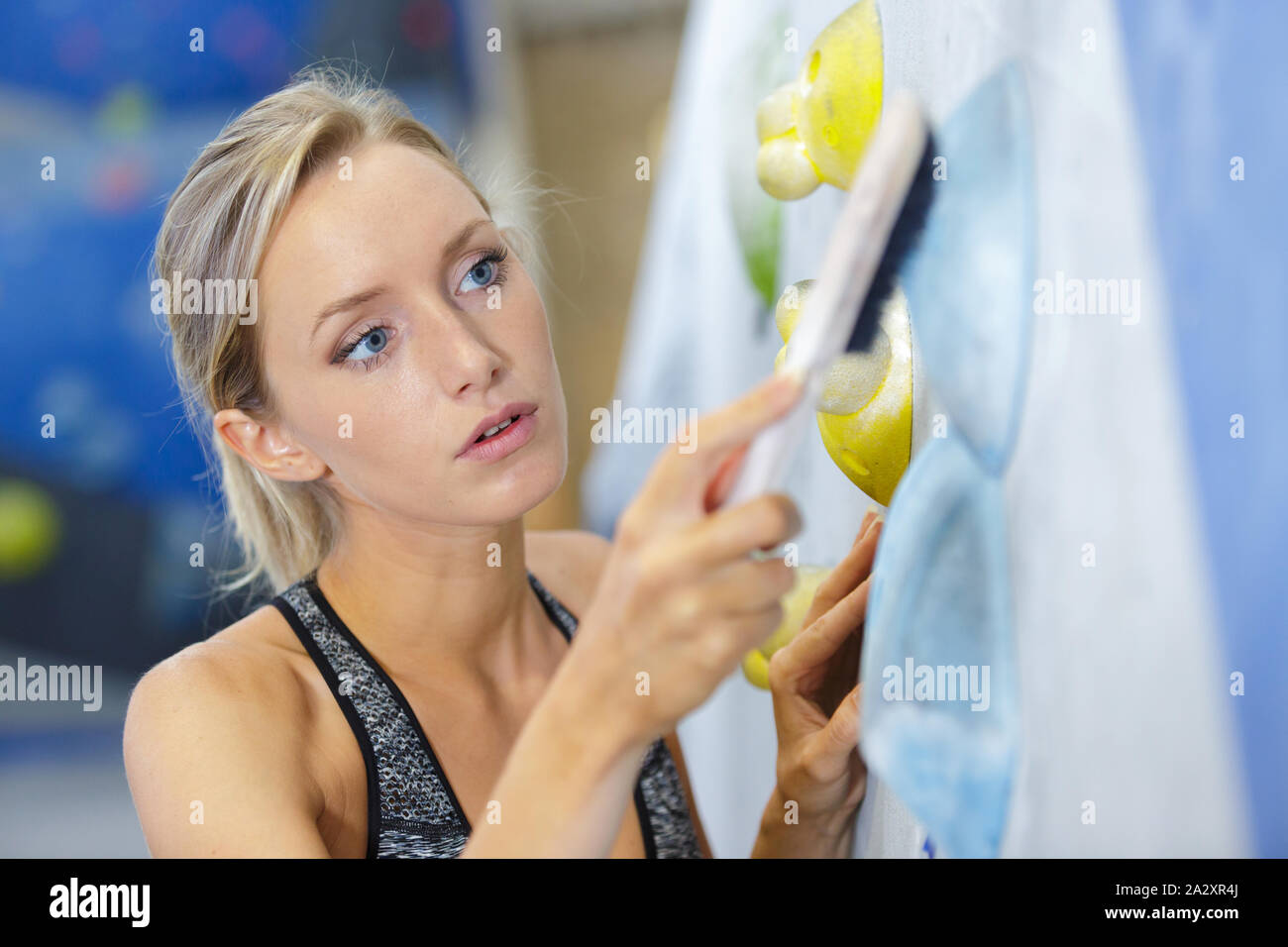 wall climbing center worker brushing the foothold Stock Photo