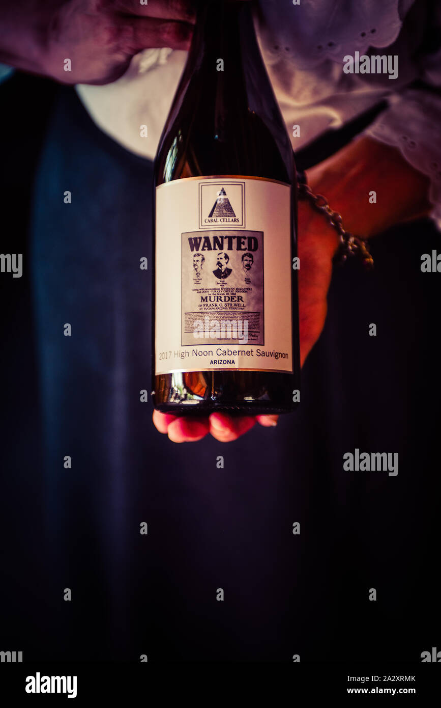 Close up of Woman holding Cabal Cellars red wine bottle with Wanted poster theme label named High Noon Cabernet Sauvignon in Tombstone, AZ, USA Stock Photo