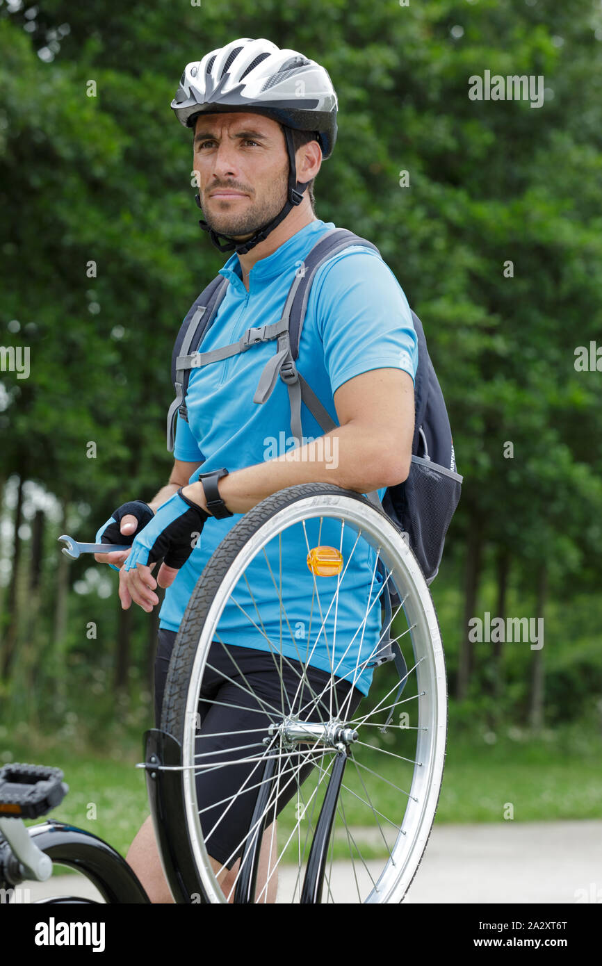 biker leaning on bicycle wheel Stock Photo