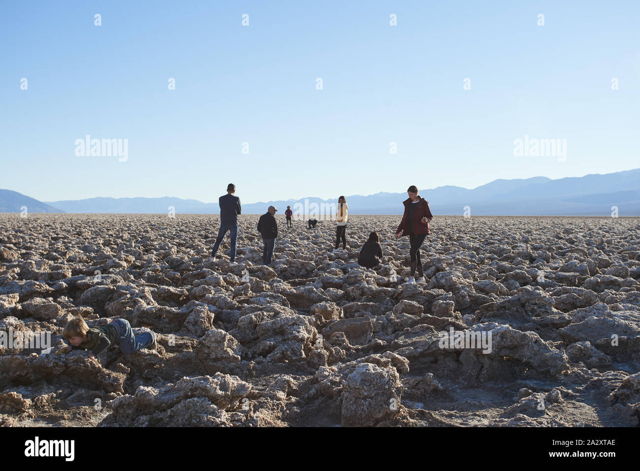 Visitors explore Devil's Golf Course, a large salt pan on the floor of Death Valley in California on Wednesday, Jan 2, 2019. Stock Photo