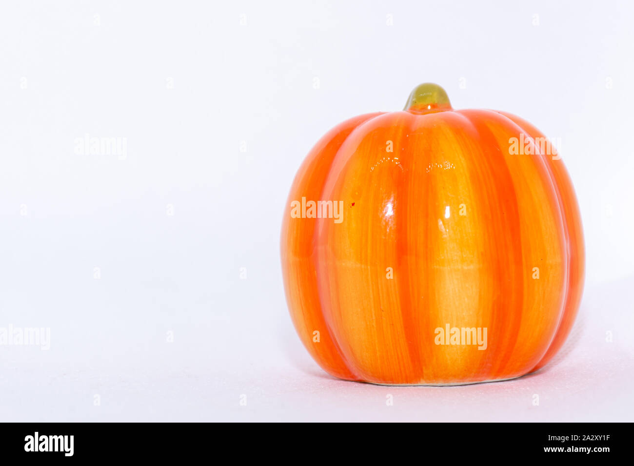 Bright orange festive pumpkin ornament on an isolated white background for fall thanksgiving and halloween season. Stock Photo