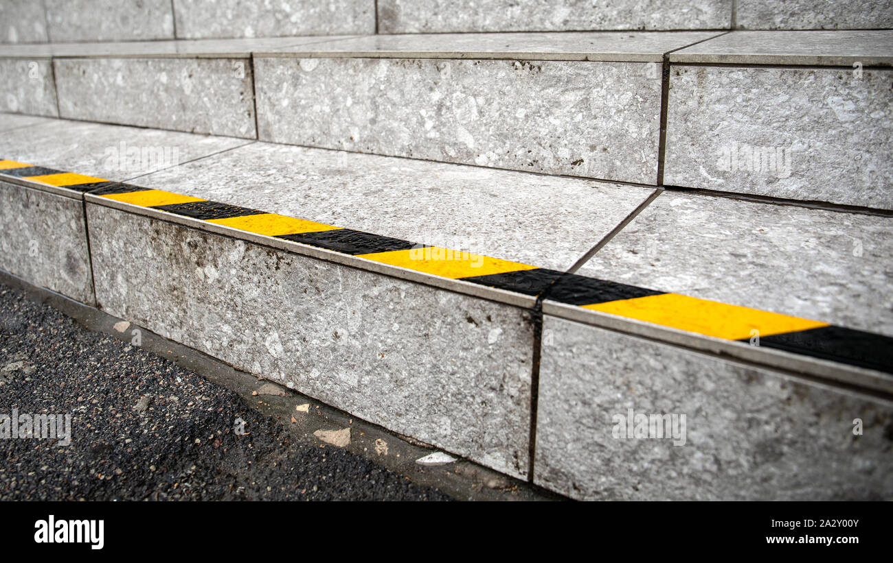 Yellow anti slip warning tape on stairs outdoors for safety Stock Photo