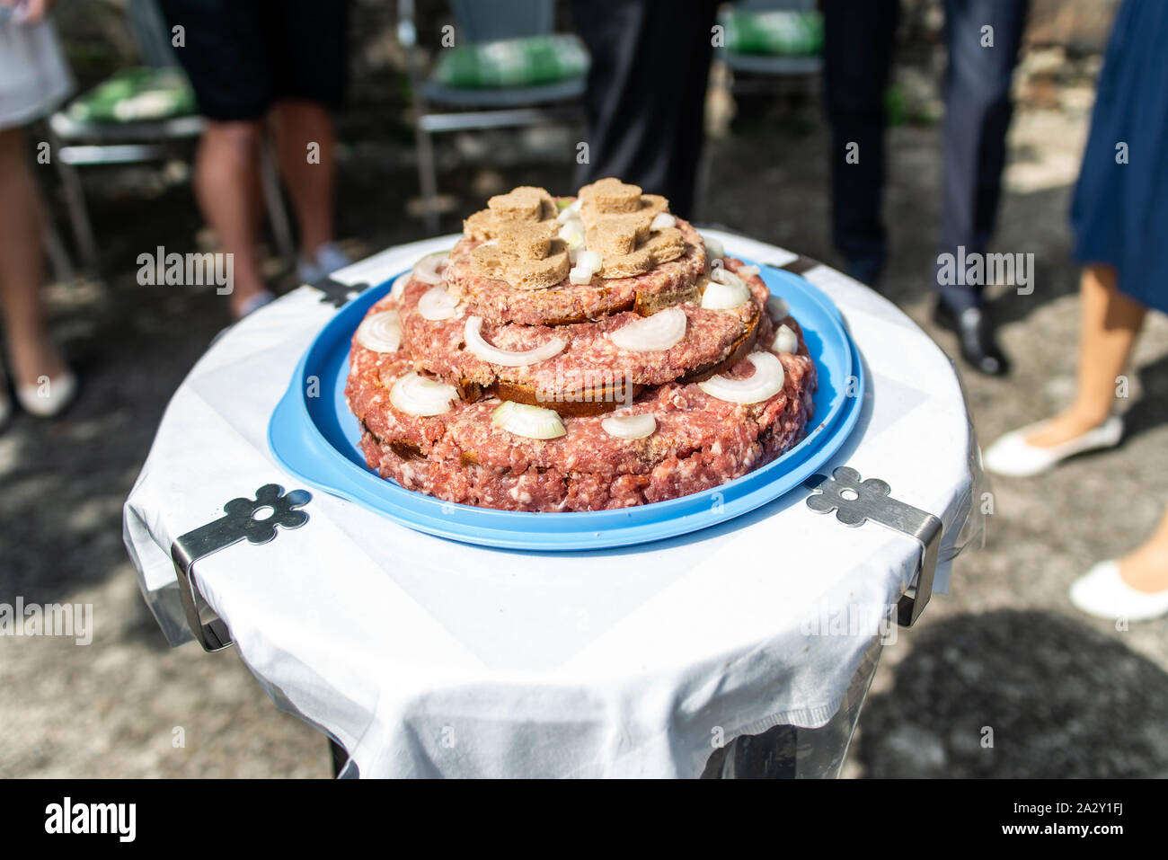 Wedding Cake raw Atriaux ground pork cuisine burgers on a slate tray with onion, rosemary, peppercorns and salt, served on a wedding close-up Stock Photo