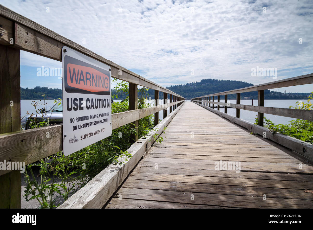NORTH VANCOUVER, BC, CANADA - SEPT 1, 2019: A caution sign at the pier near the boat slip in Cates Park. Stock Photo