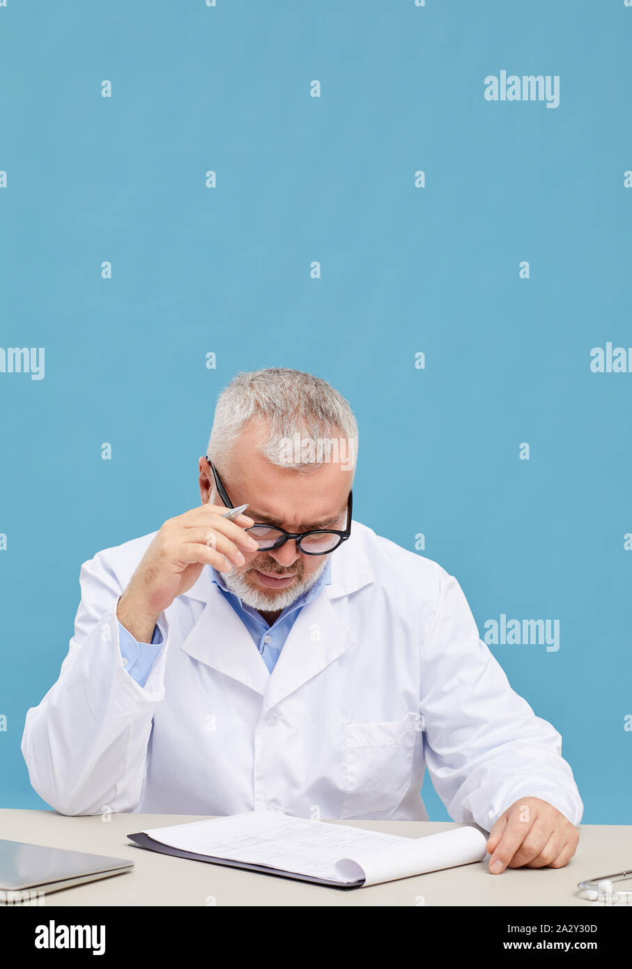 Mature doctor thinking holding hi-res stock photography and images - Alamy