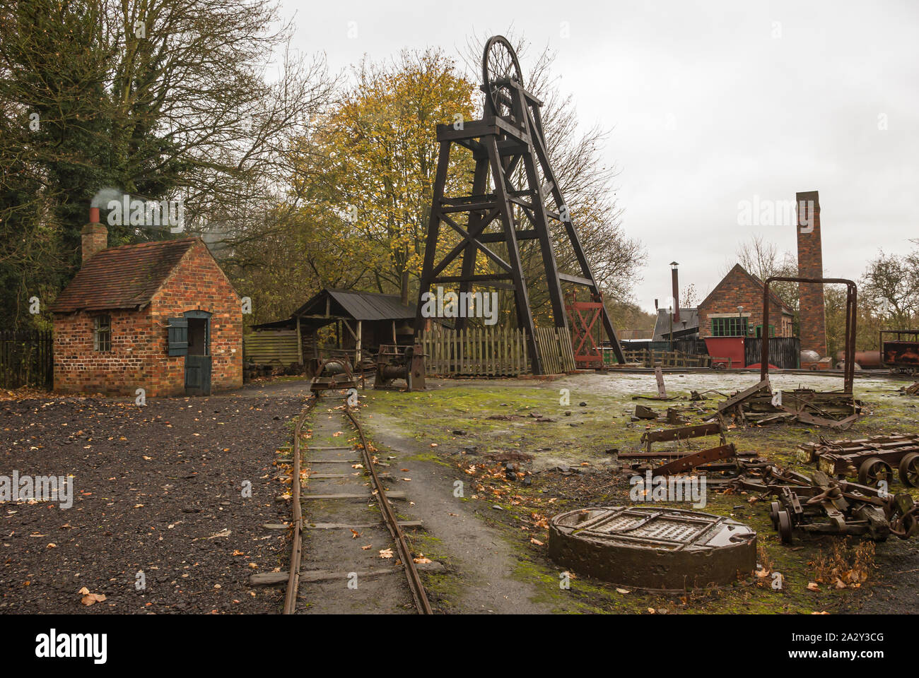 Old pit head at top of mine shaft with narrow-gauge railway tracks in foreground Stock Photo