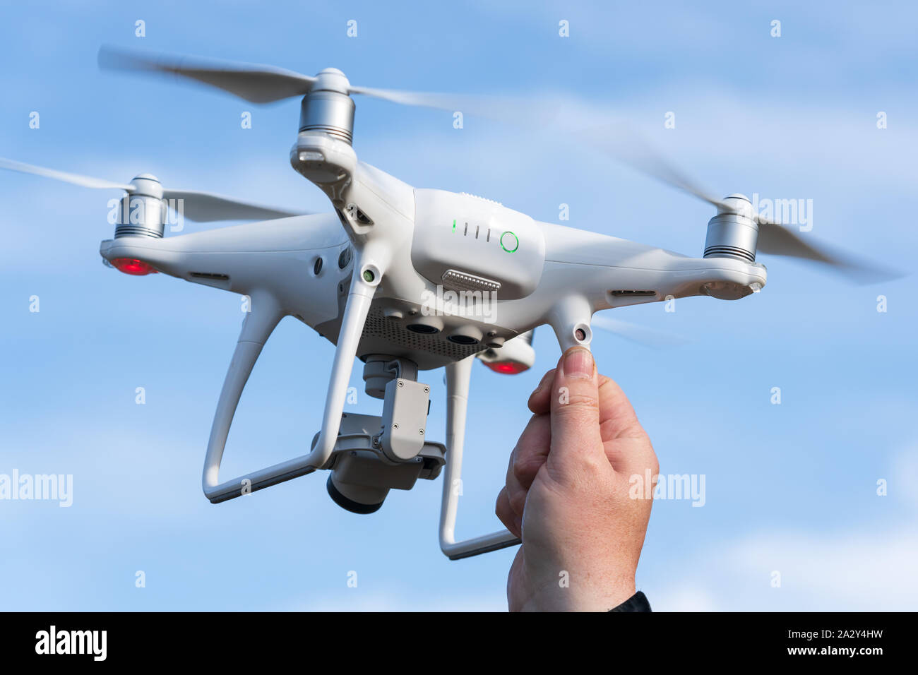 Male hand catches / launches professional drone quad copter DJI Phantom 4  Pro with digital camera 4K on background of autumn blue sky. Kamchatka  Stock Photo - Alamy