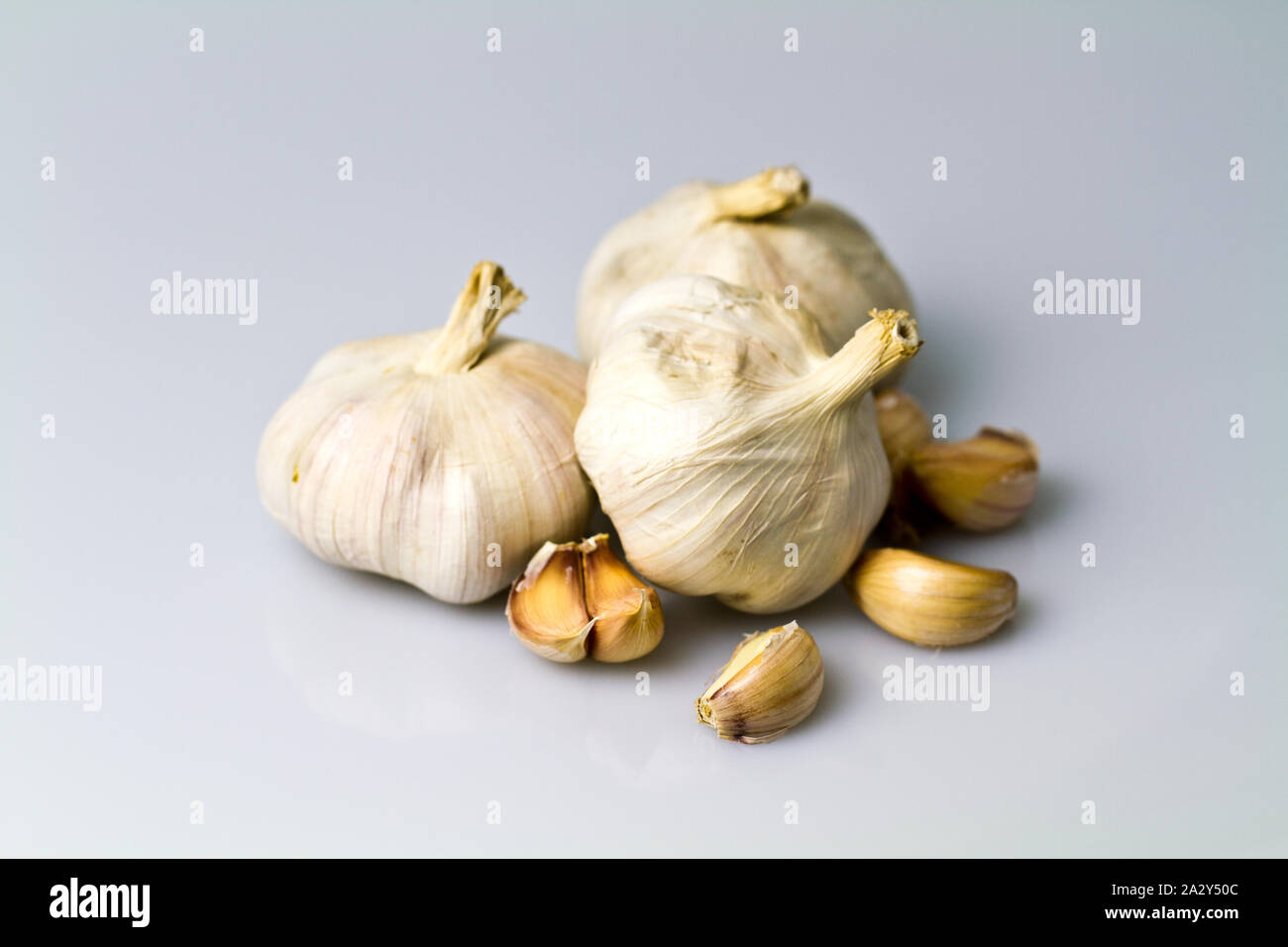 cloves and bulbs of garlic on white table and white background Stock ...