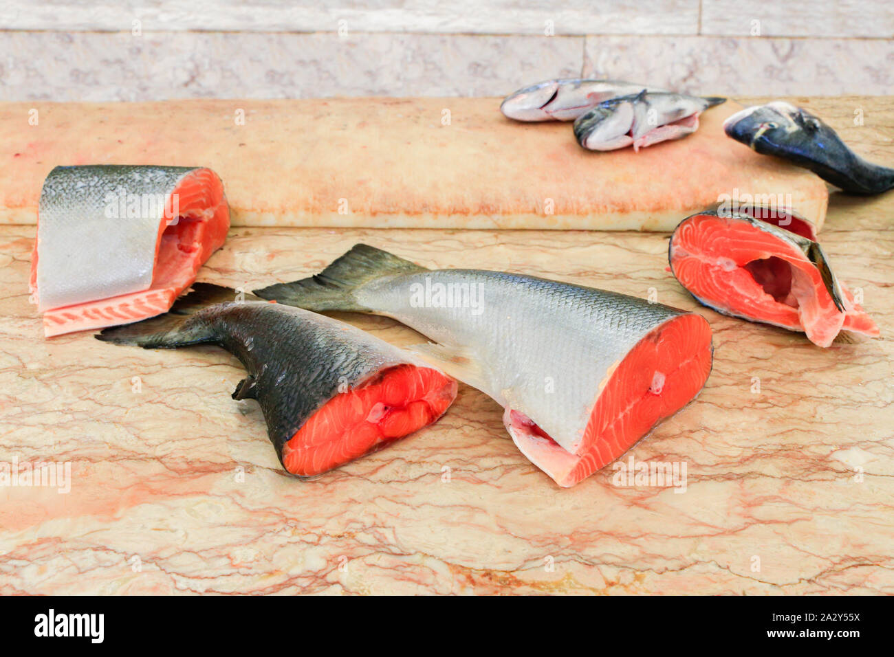 Pieces of cut fresh  salmon fishes lying  on marble table Stock Photo
