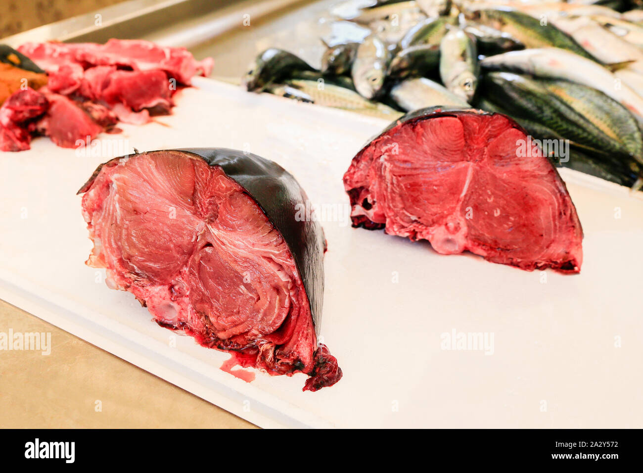 Parts of chopped red tuna fishes on the counter at market Stock Photo