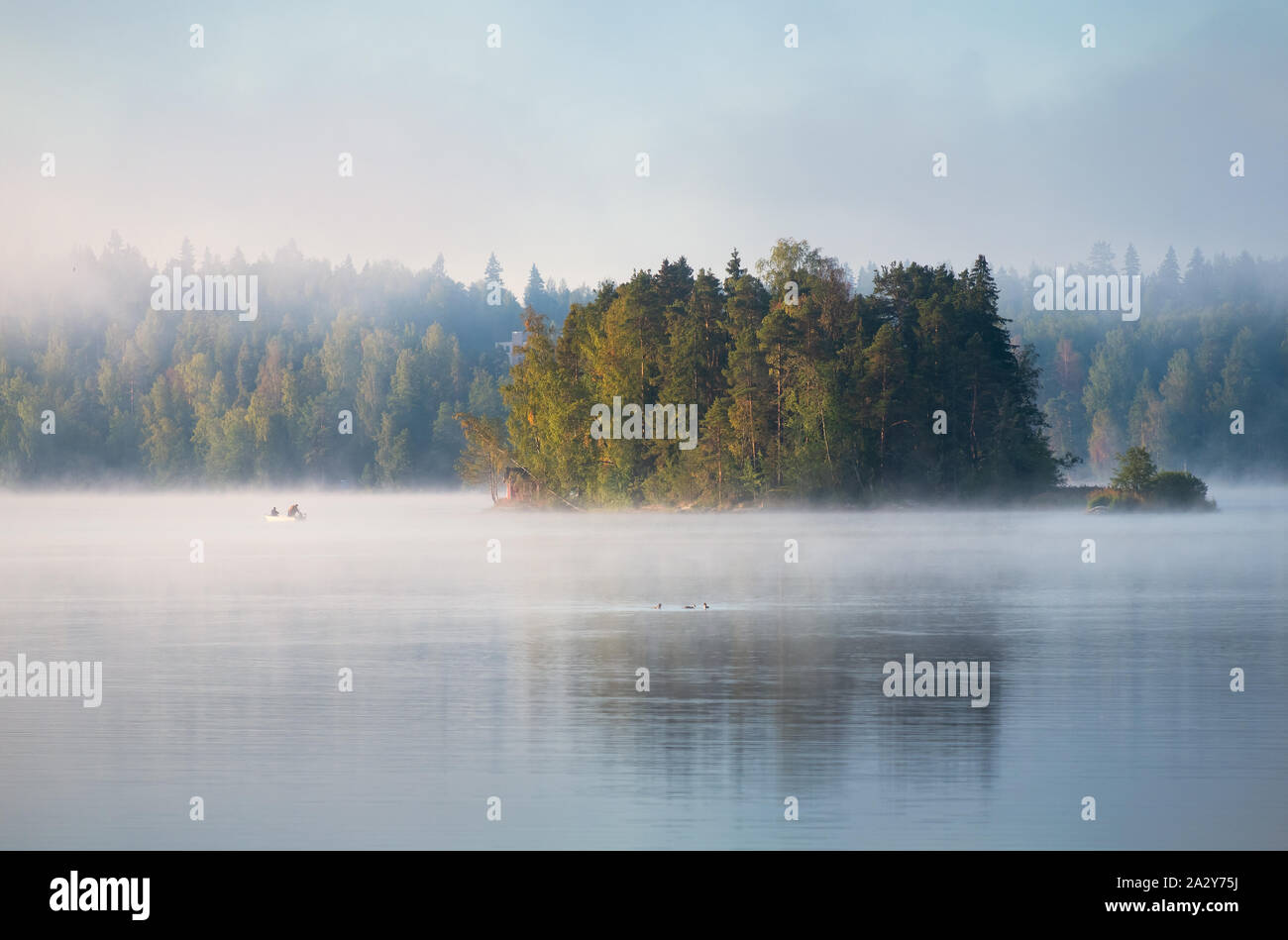 Misty landscape with fisherman and beautiful morning light at mood summer morning in Finland Stock Photo