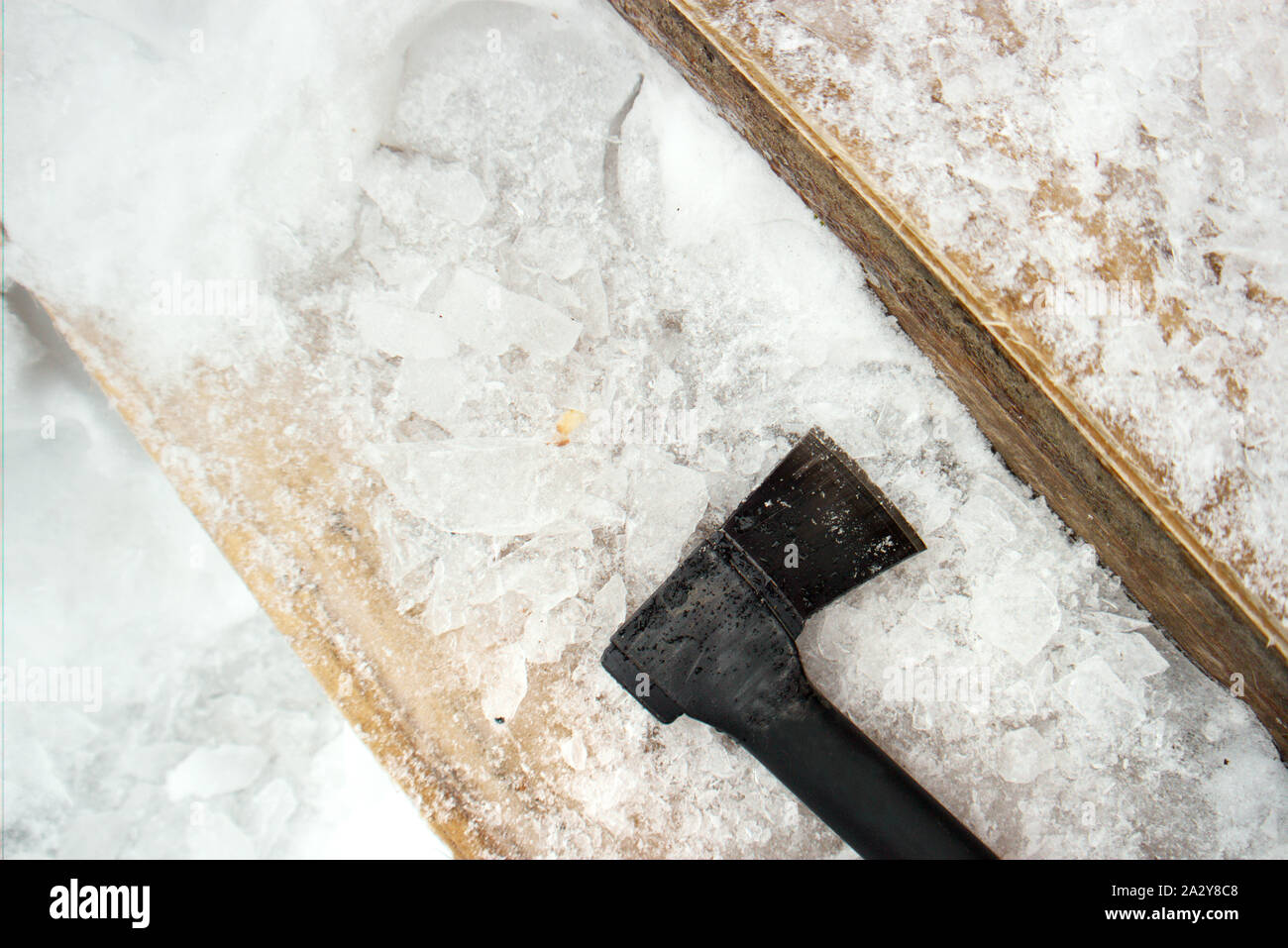 Removing ice from the slippery steps with axe, overhead closeup Stock