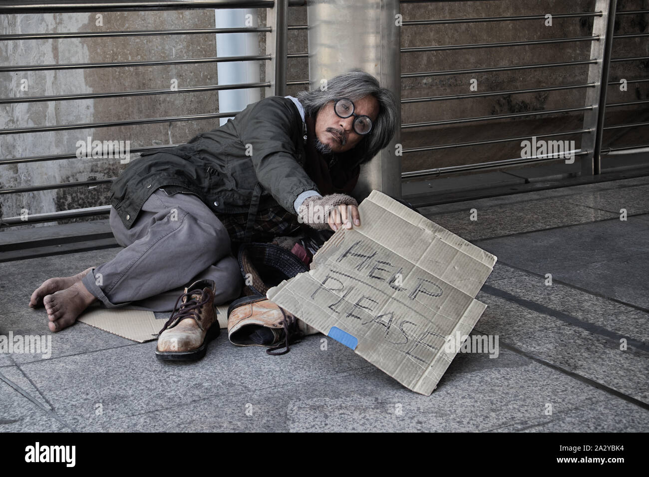 Homeless people living in various cities He waited and needed help from the kind people to give him all the necessary things, clothing, bread, water, Stock Photo