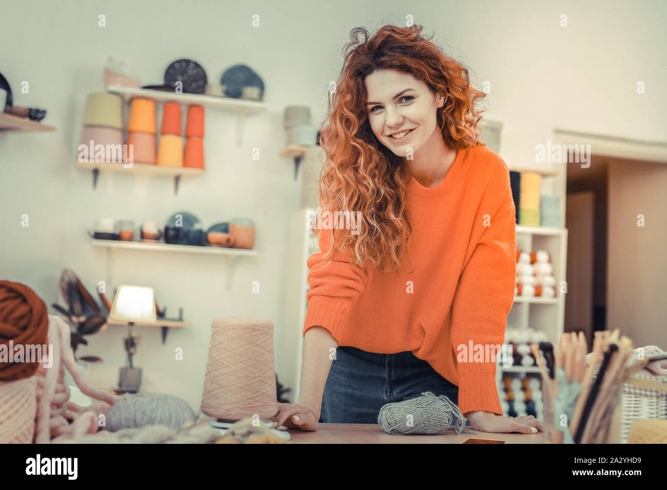 Positive delighted woman leaning on her workplace Stock Photo - Alamy