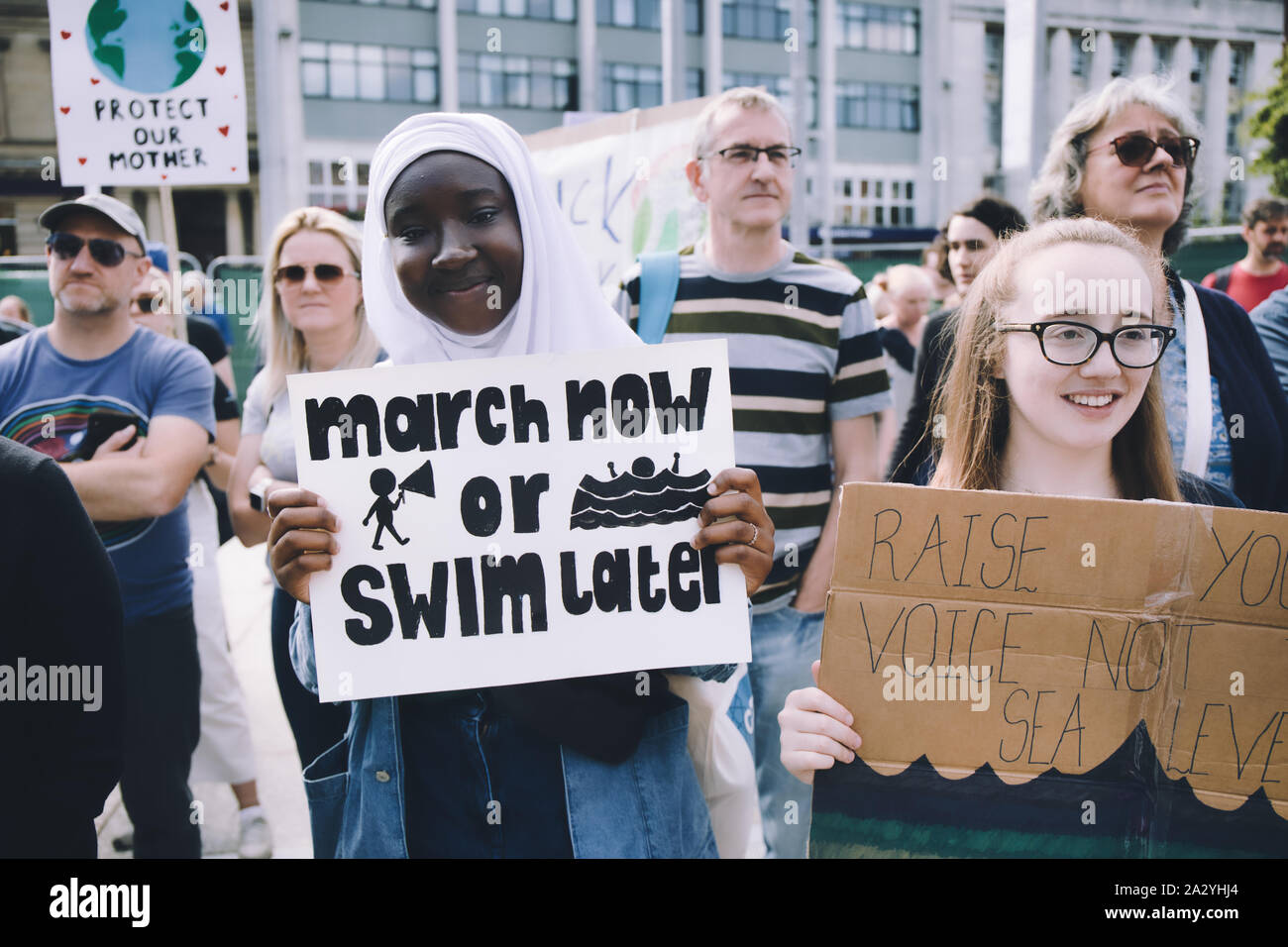 Two young female protesters holding climate change placards at the 20th September global climate strike, Old Market Square, Nottingham, England Stock Photo