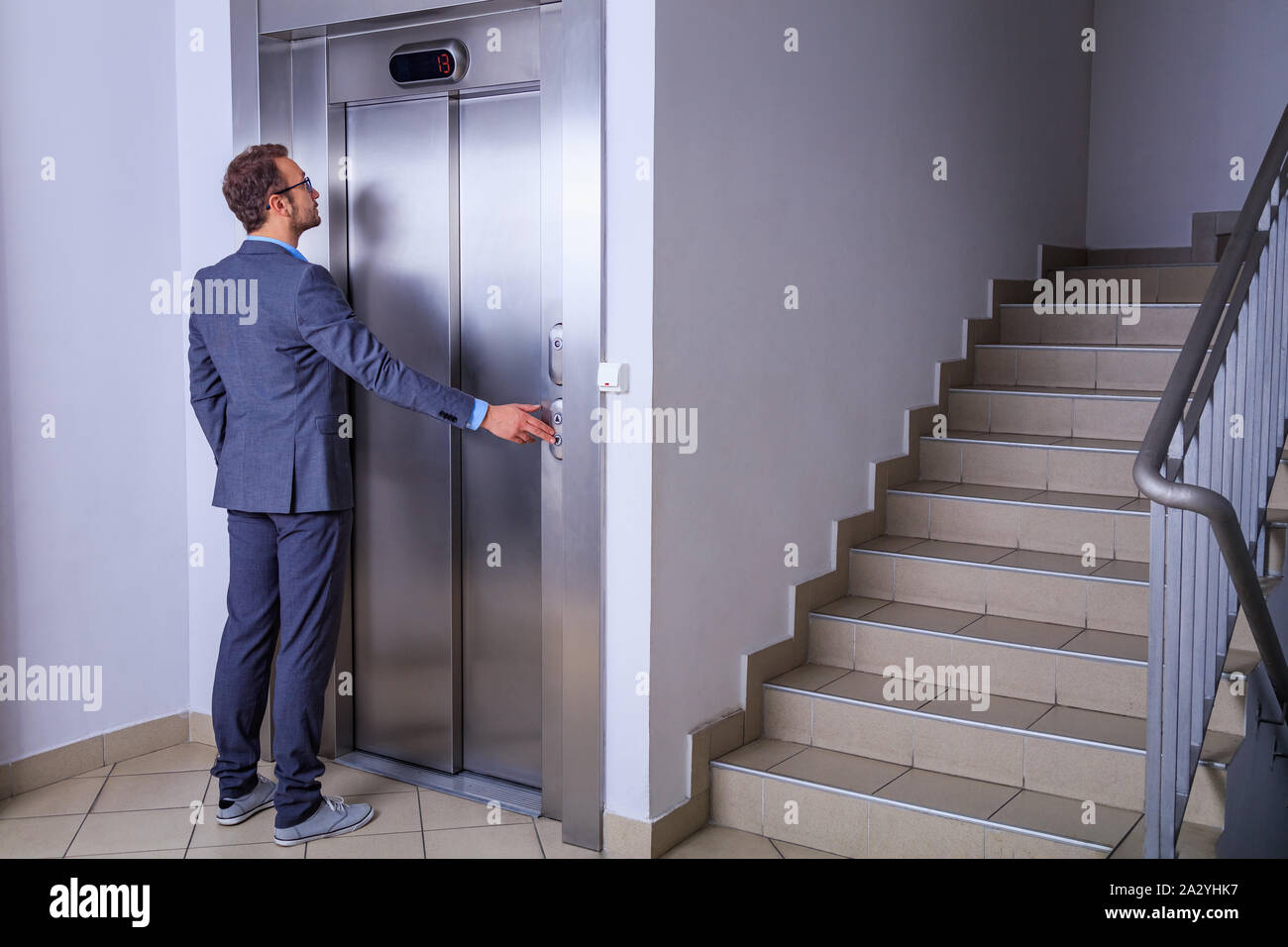 Businessman calling the elevator Stock Photo - Alamy