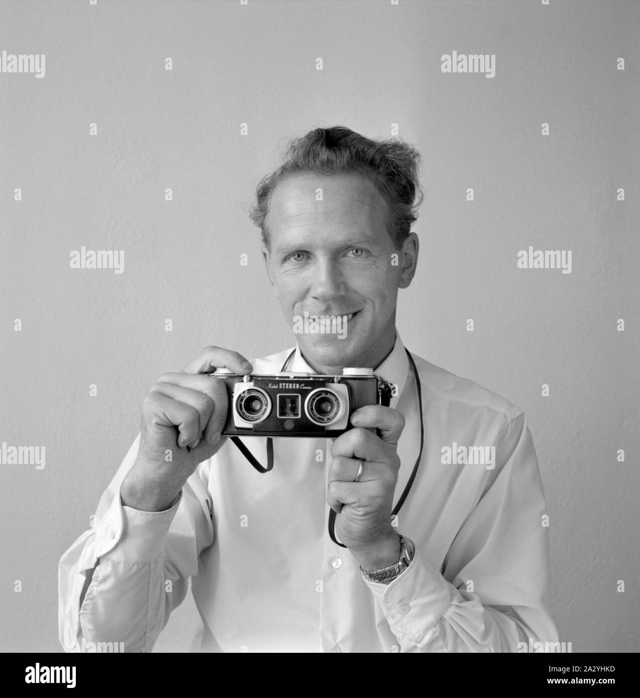 Camera history. A man with a Kodak Stereo Camera. A 35 mm stereo camera produced between 1954 och 1959. The camera took twin shots of the scene, and the slides could then be viewed in dedicated image viewers to experience the depth and effect of the twin lense photography. Sweden 1955 Stock Photo