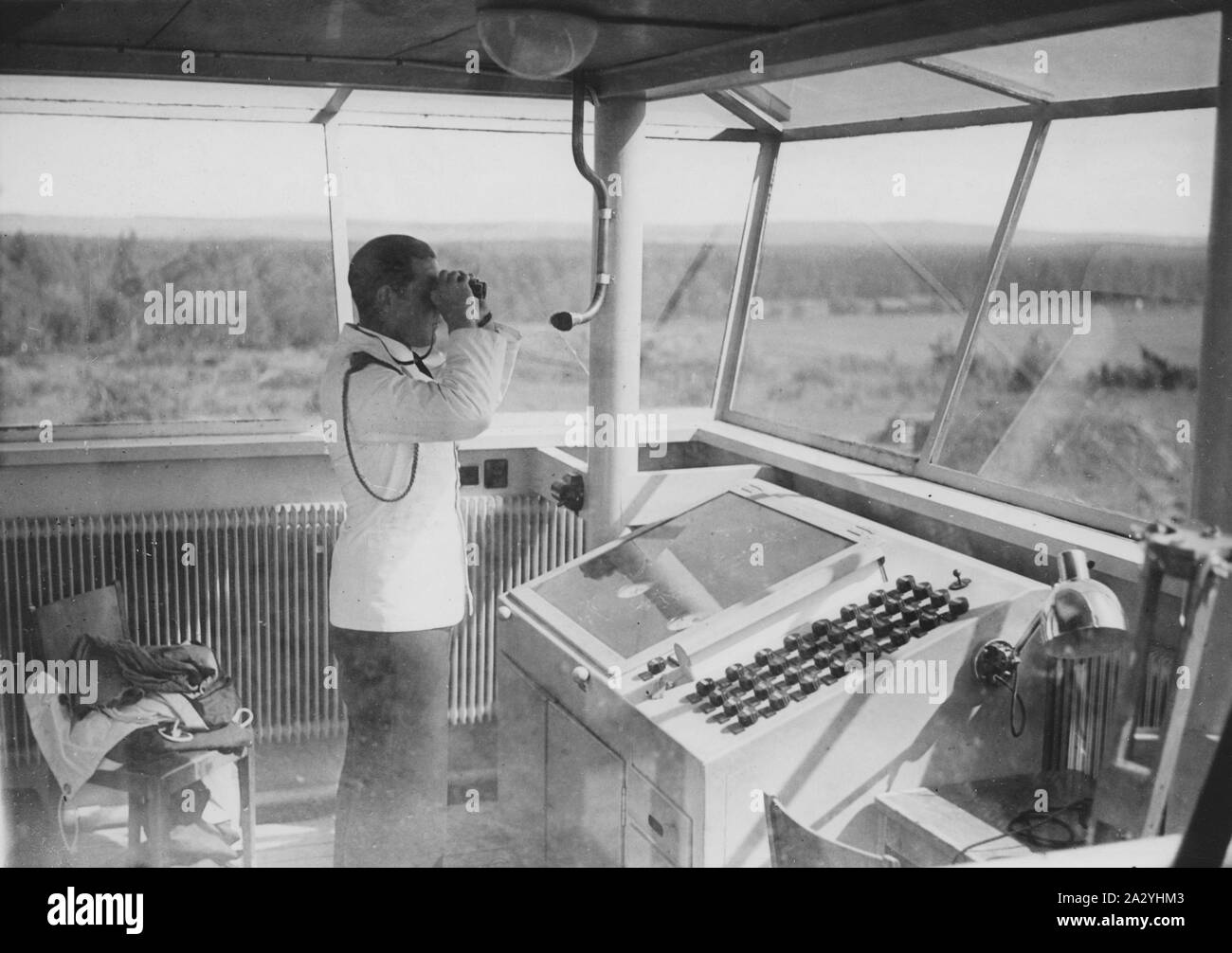 Air traffic controller in the 1930s. An officer in the airport control tower is monitoring the runway with binoculars. Bromma airport Stockholm. The airport that was opened for traffic may 23 1936. Stock Photo