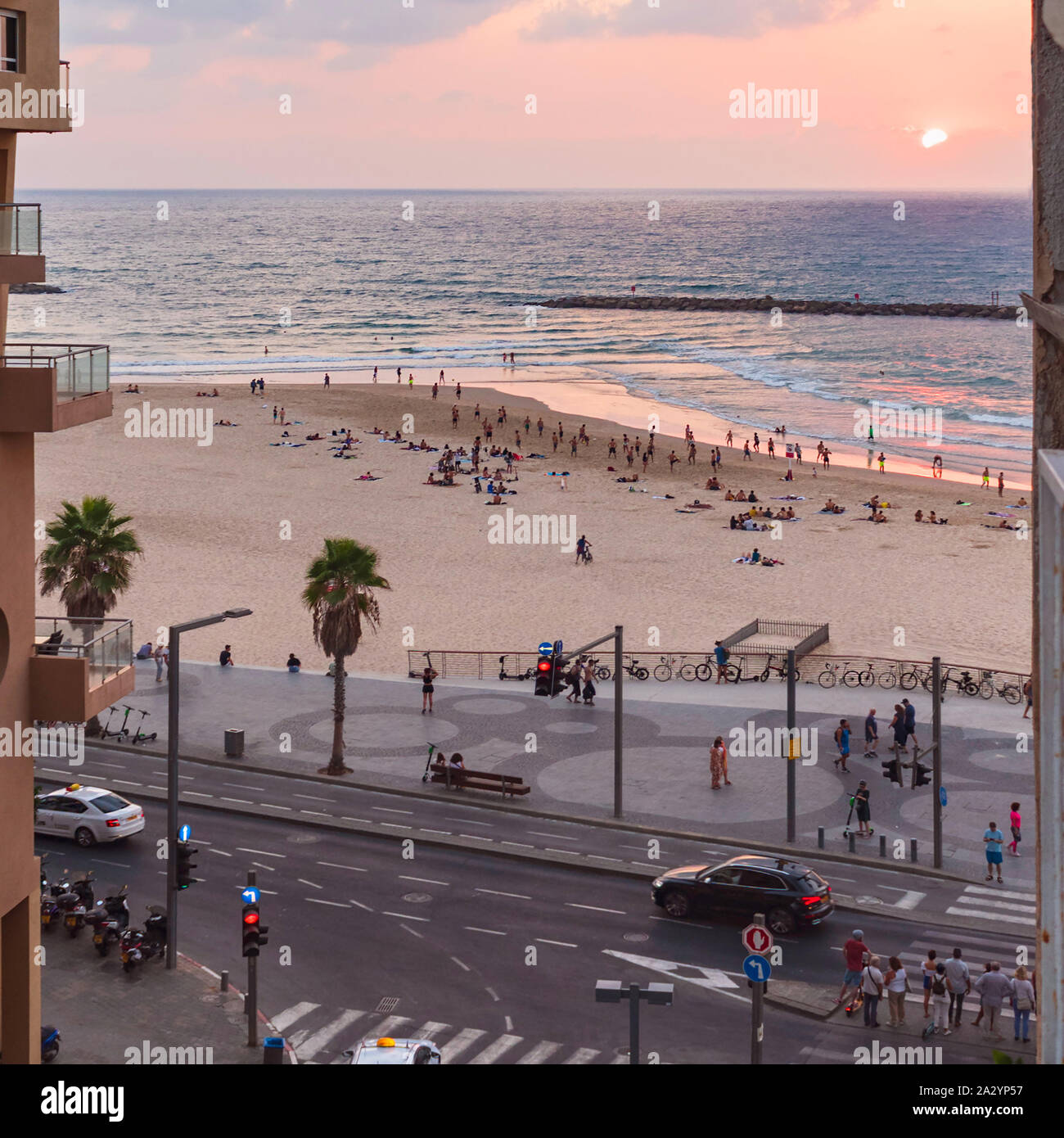 sunset view of people enjoying trumpledor beach and the promenade in tel aviv in israel with samuel shmuel street in the foreground Stock Photo