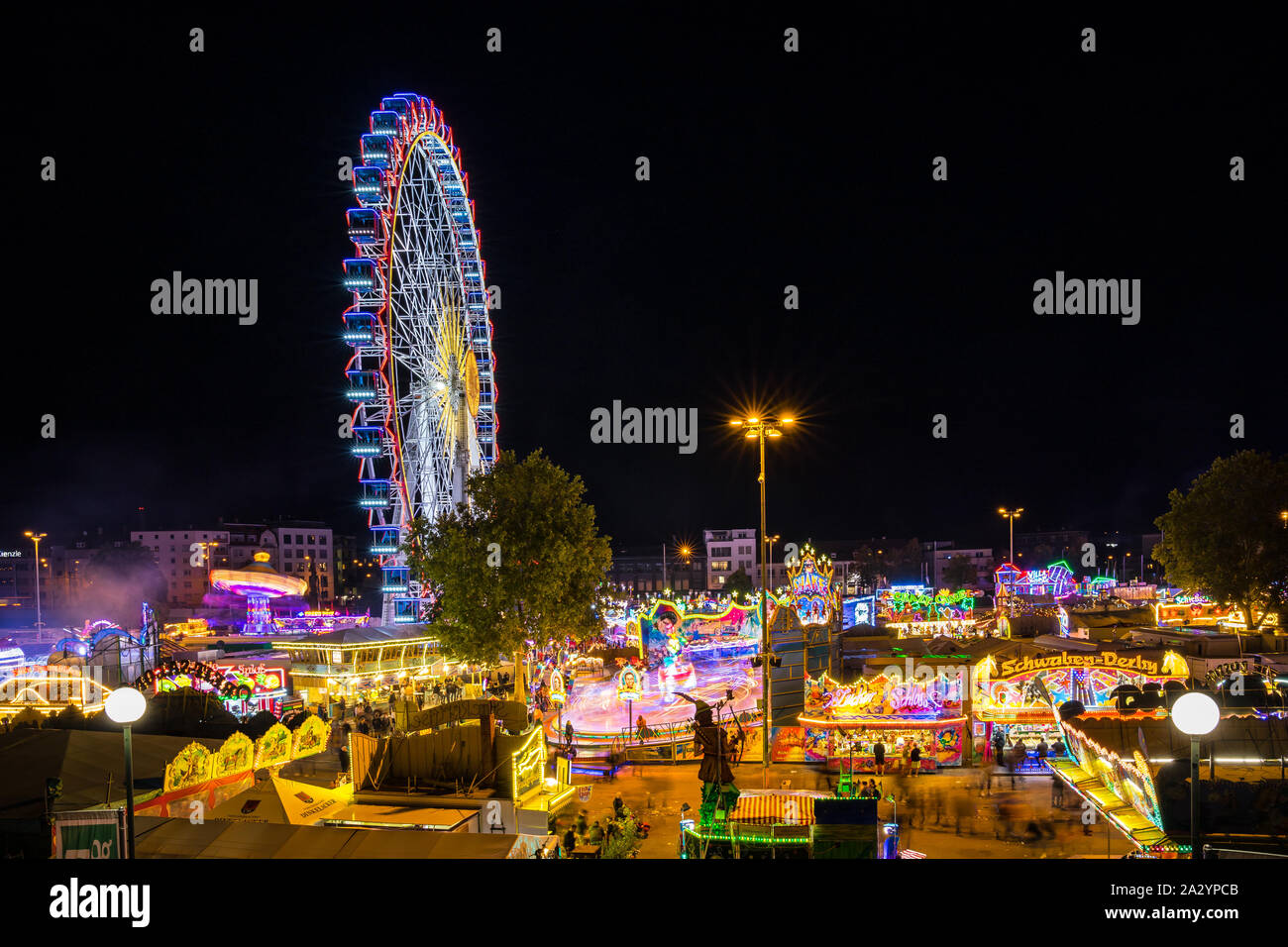 Stuttgart, Germany, October 3, 2019, Canstatter wasen oktoberfest folk festival illuminating the night with many carousel, big wheel and food offers b Stock Photo